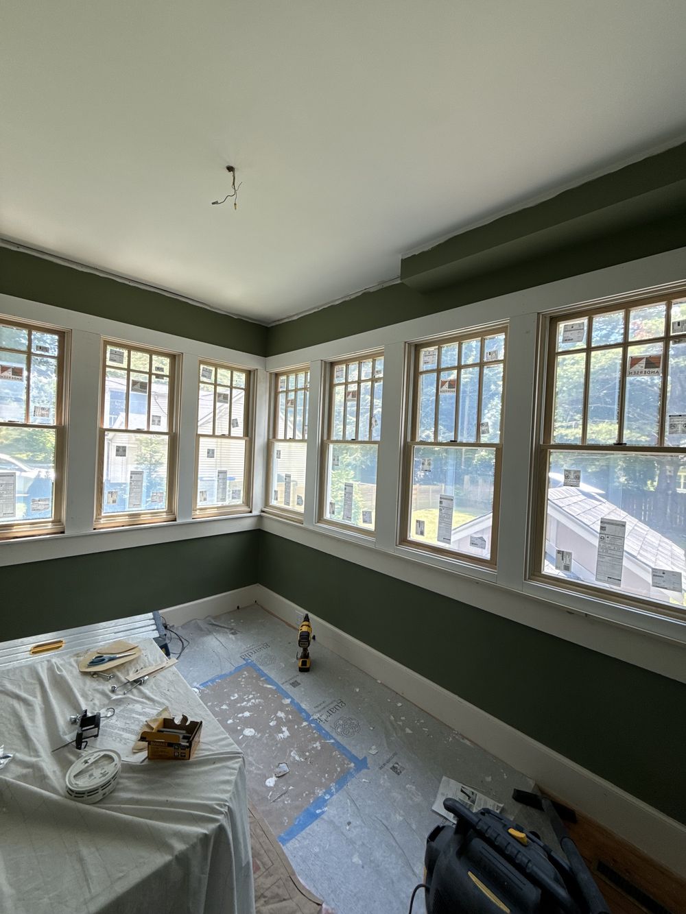 The office during finishing, deep green walls and a bank of new windows on two sides