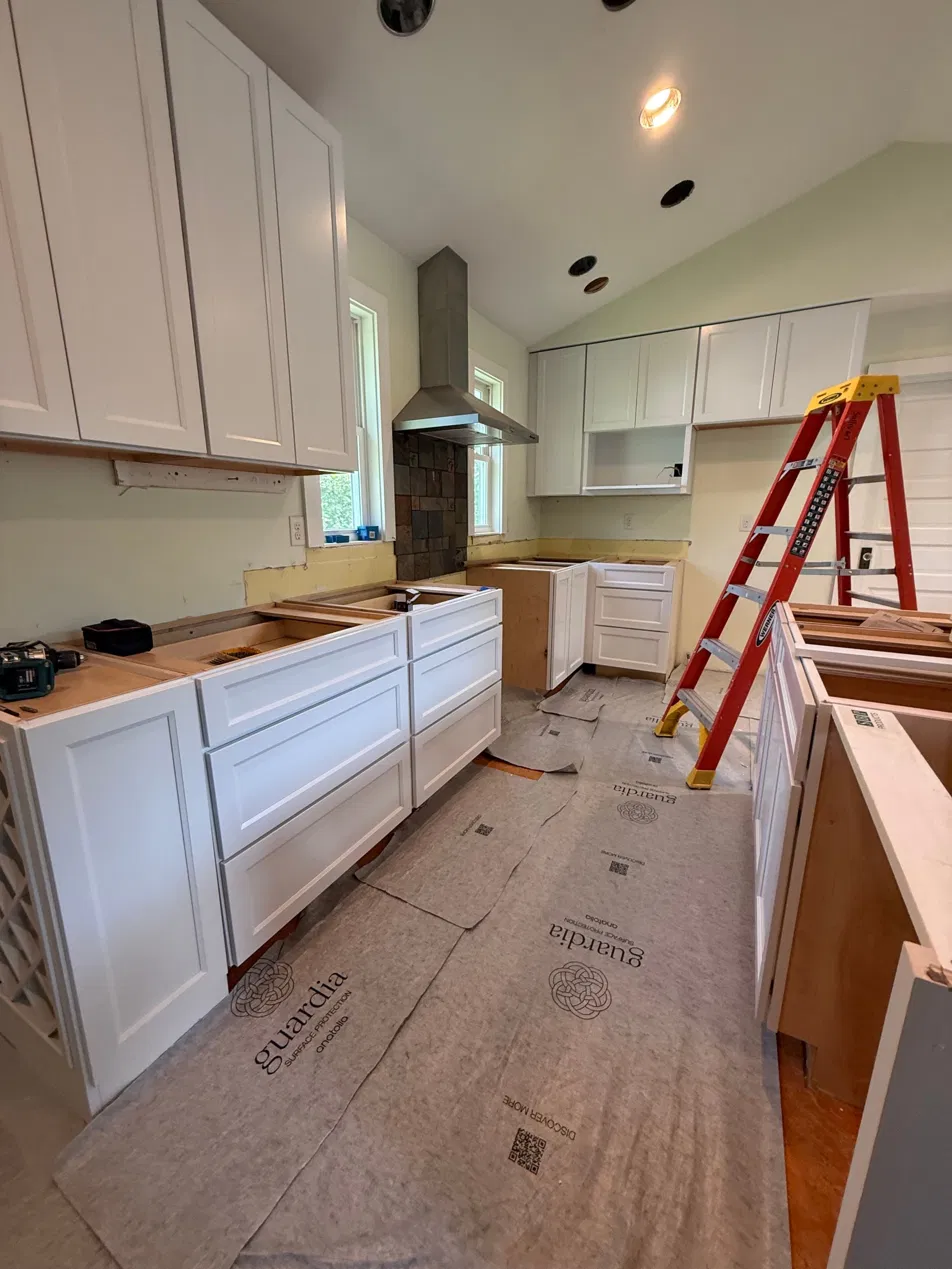 Cabinets set and shimmed level during installation, Guardia floor protection laid over the subfloor